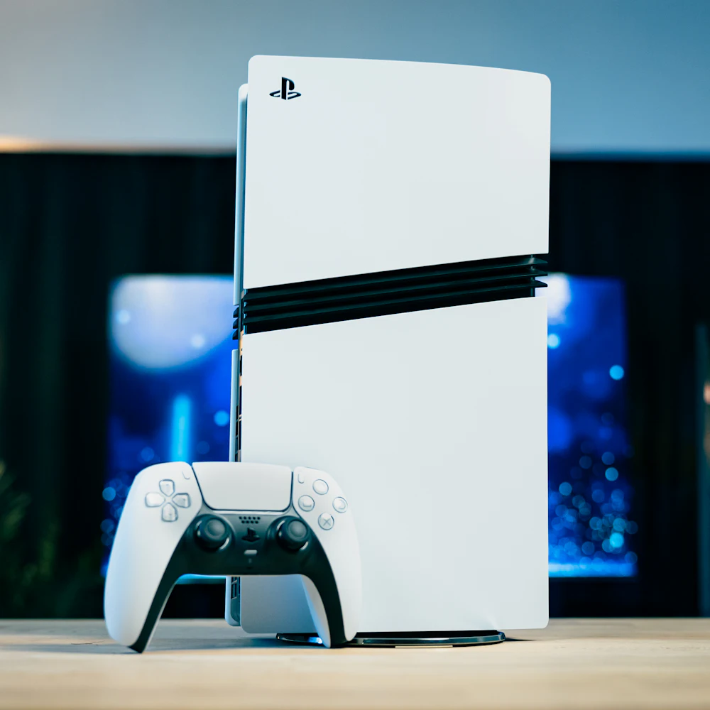 White PlayStation 5 console with a DualSense controller on a wooden table