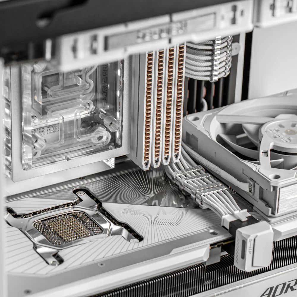 Close-up of a white custom liquid-cooled gaming PC interior with copper heat pipes and braided cables